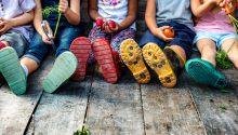 Becoming Sons and Daughters of God; photo of children sitting on a wooden deck as a figurative illustration of children of God
