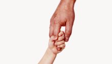 Photo of a father's hand holding a small child's hand to illustrate the article Fumbling Through Parenthood: What Becoming a Dad Has Taught Me About God
